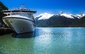 Pohled na kotvící výletní loď a zasněžené hory v Skagway, Aljaška